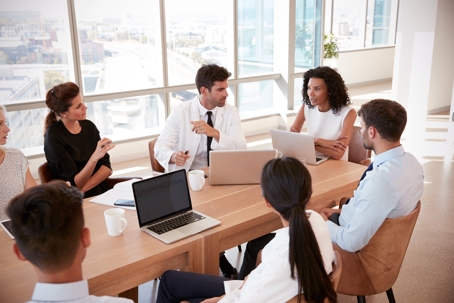 Women leading meeting with colleagues.