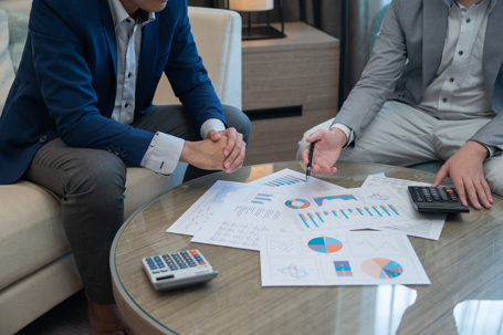 Two men reviewing financial statements at a table