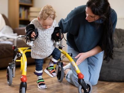 Mother helping child with cerebral palsy