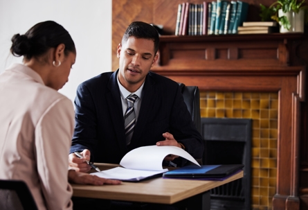 Man showing paperwork to female client