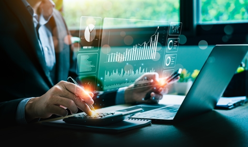 Man typing on computer with financial charts