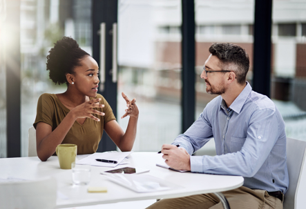 Woman and man sitting at table with paperwork.