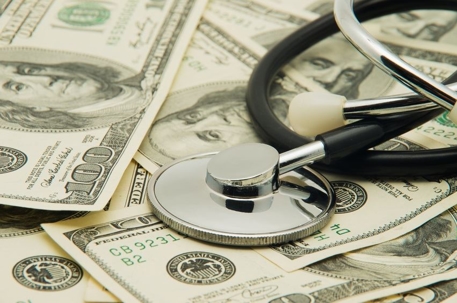 A stethoscope on top of a pile of $100 bills